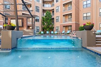 A large swimming pool in front of apartment buildings.